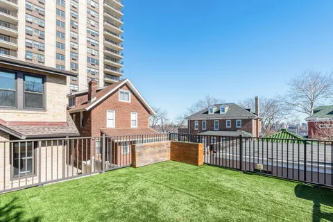 a view of a house with wooden deck and a big yard