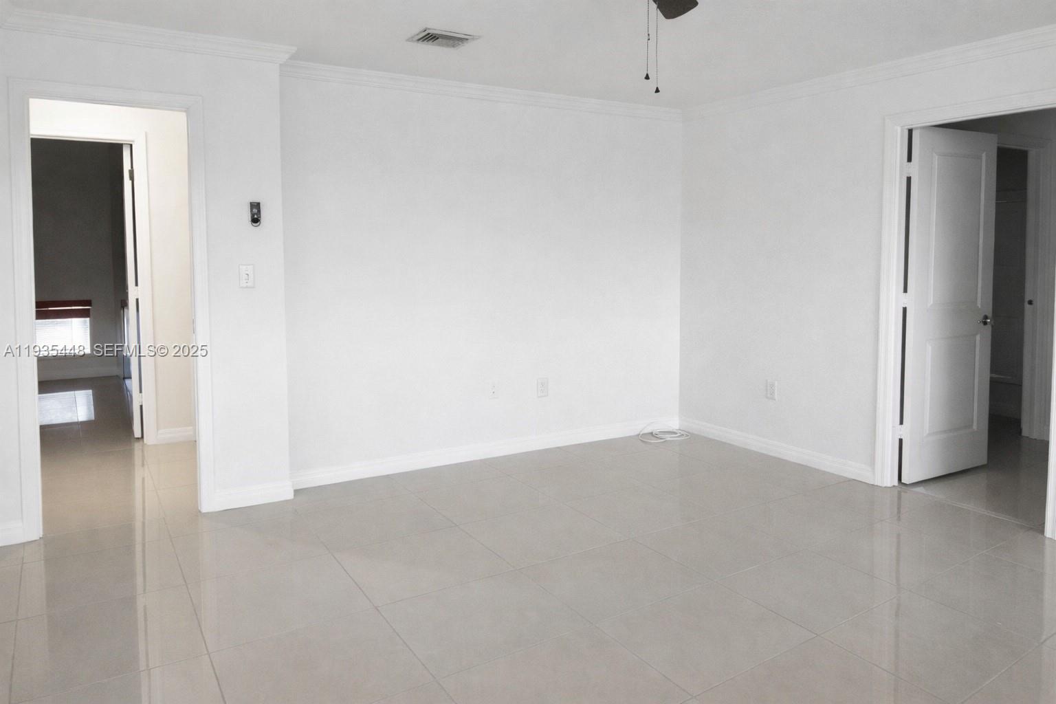 14964 Southwest 32nd Terrace Miami, FL 33185 - Photo 7 of 10 en empty room with wooden floor and windows