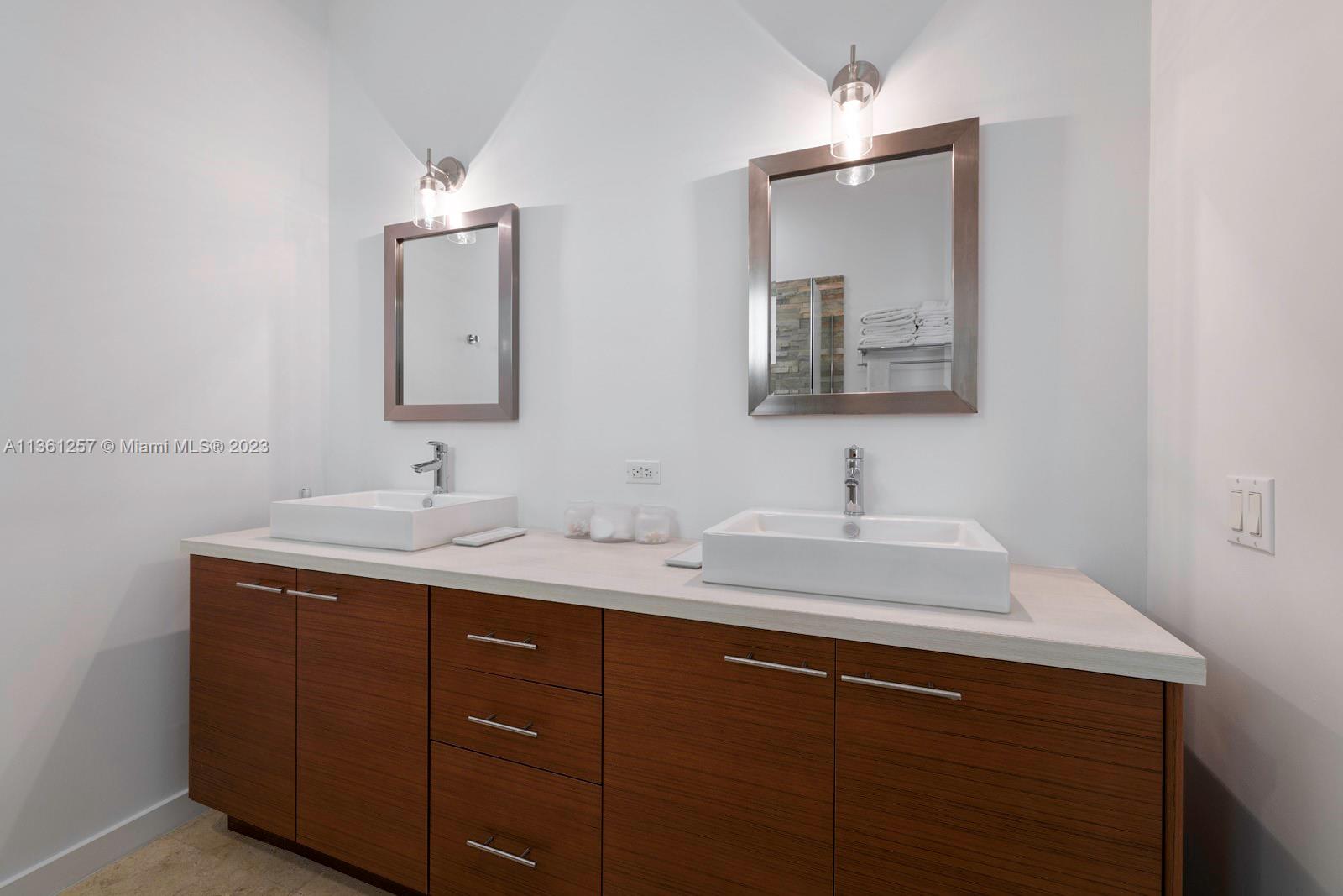 3894 Main Highway Coconut Grove, FL 33133 - Photo 15 of 28 a bathroom with a double vanity sink and a mirror