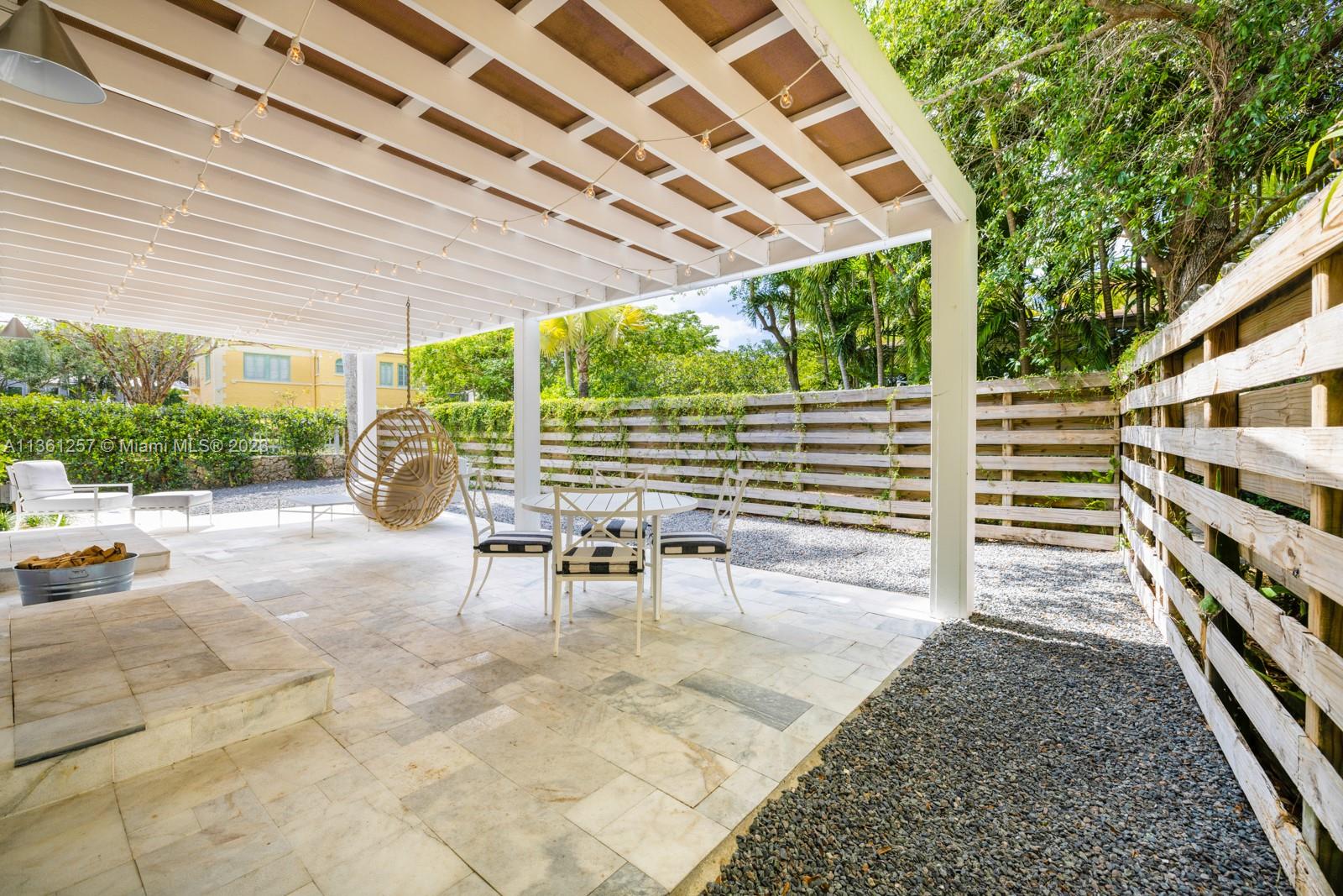 3894 Main Highway Coconut Grove, FL 33133 - Photo 19 of 28 a view of a patio with table and chairs with wooden floor and fence