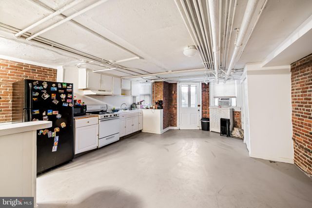 a kitchen with stainless steel appliances kitchen island granite countertop a refrigerator and a stove top oven