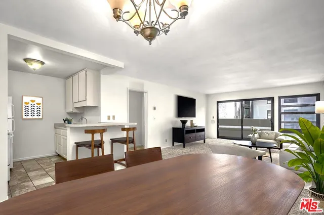 a living room with furniture a chandelier and a flat screen tv