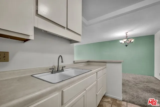 a bedroom with a bed a couch and potted plant on the dresser