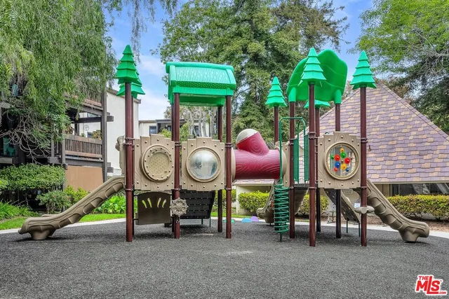 a view of swimming pool with outdoor seating and trees in the background