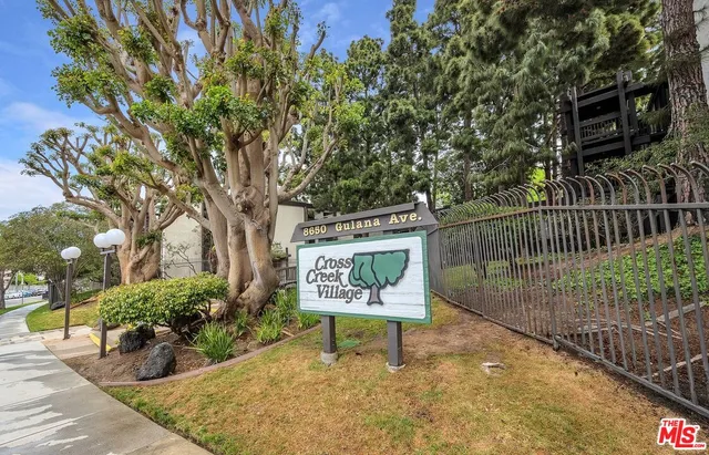 a sign board with tall trees