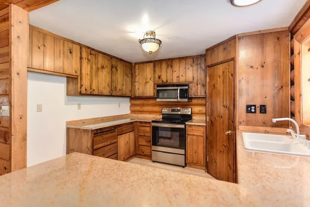 a kitchen with stainless steel appliances granite countertop a stove a sink and a microwave