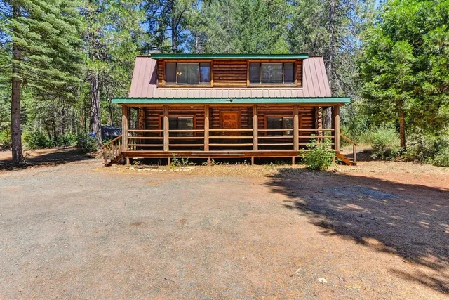 a view of a house with backyard and a tree