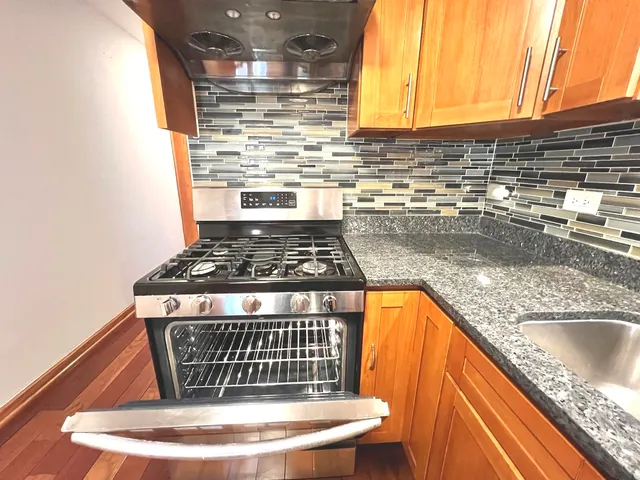 a kitchen with stainless steel appliances granite countertop a stove and a sink