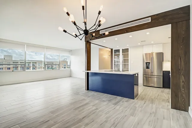 a large kitchen with stainless steel appliances granite countertop a refrigerator a oven a sink with wooden cabinets and wooden floor