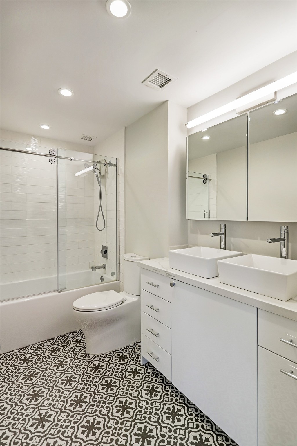 2701 Westheimer Road, Unit 8B Houston, TX 77098 - Photo 13 of 28 a bathroom with a toilet a sink a mirror a bathtub and shower