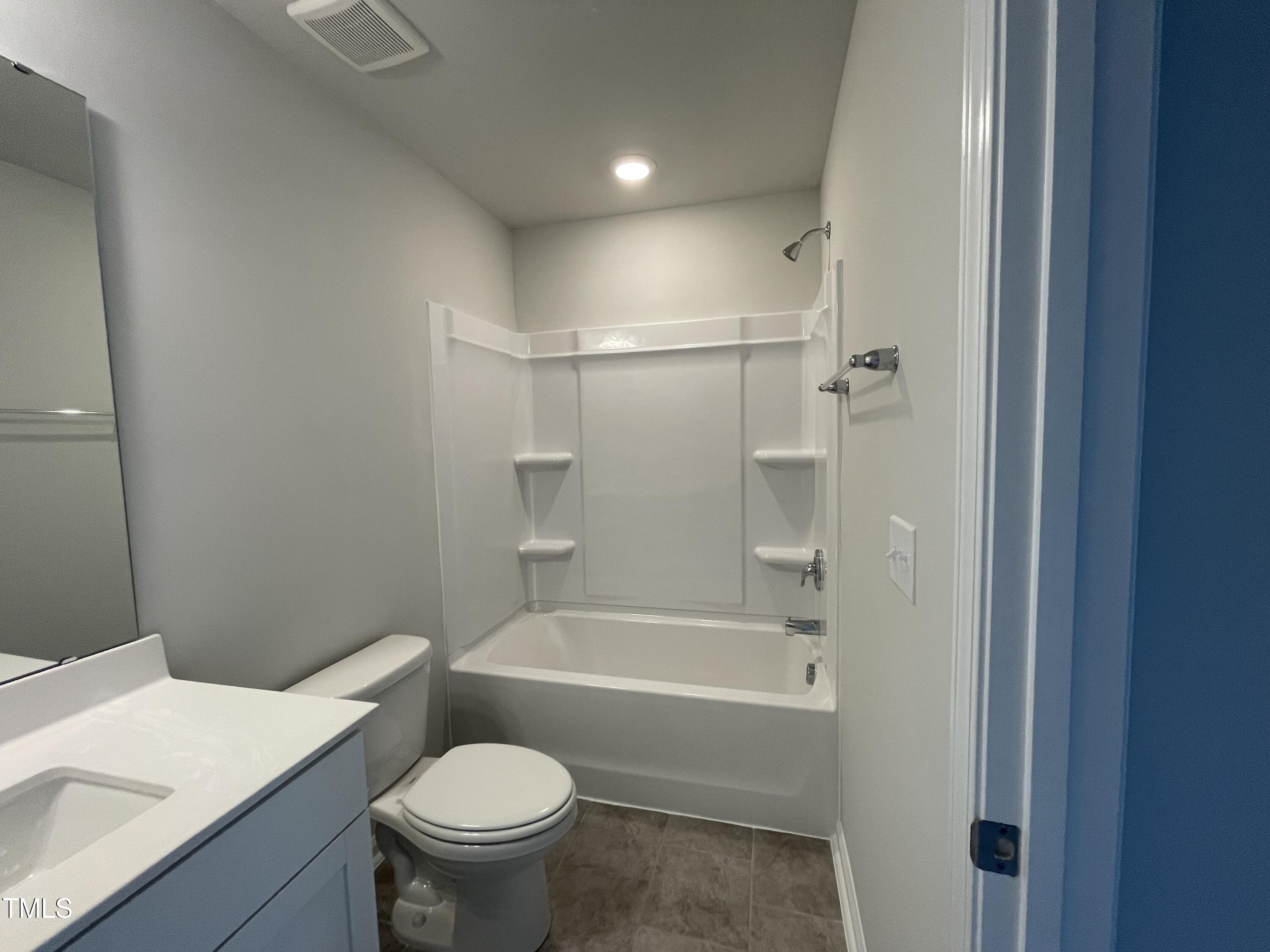 239 Paramount Drive Smithfield, NC 27577 - Photo 11 of 16 a white toilet sitting next to a bathroom sink and a bathtub