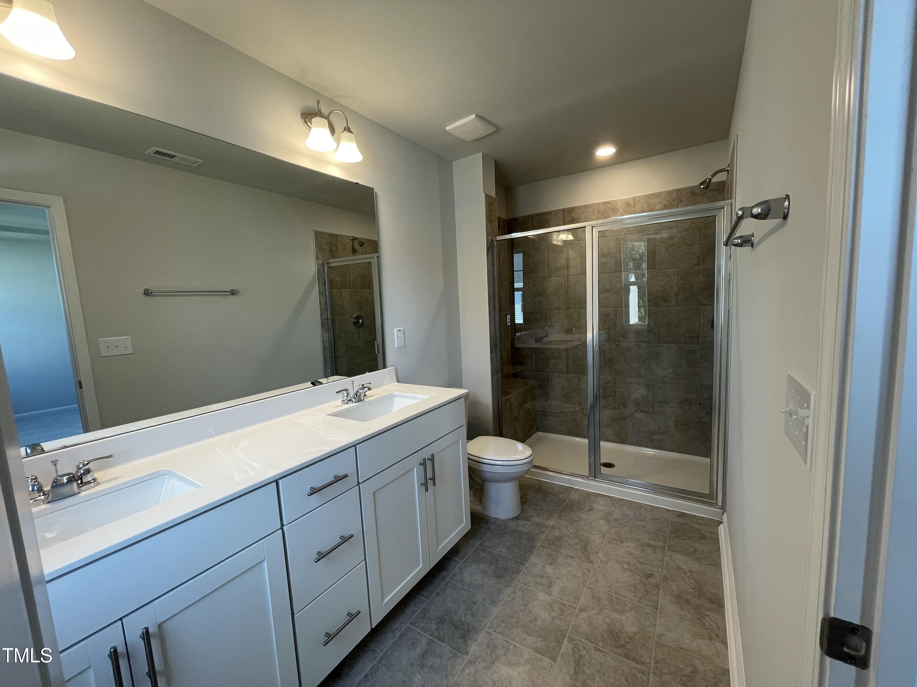 239 Paramount Drive Smithfield, NC 27577 - Photo 15 of 16 a bathroom with a shower sink vanity and toilet
