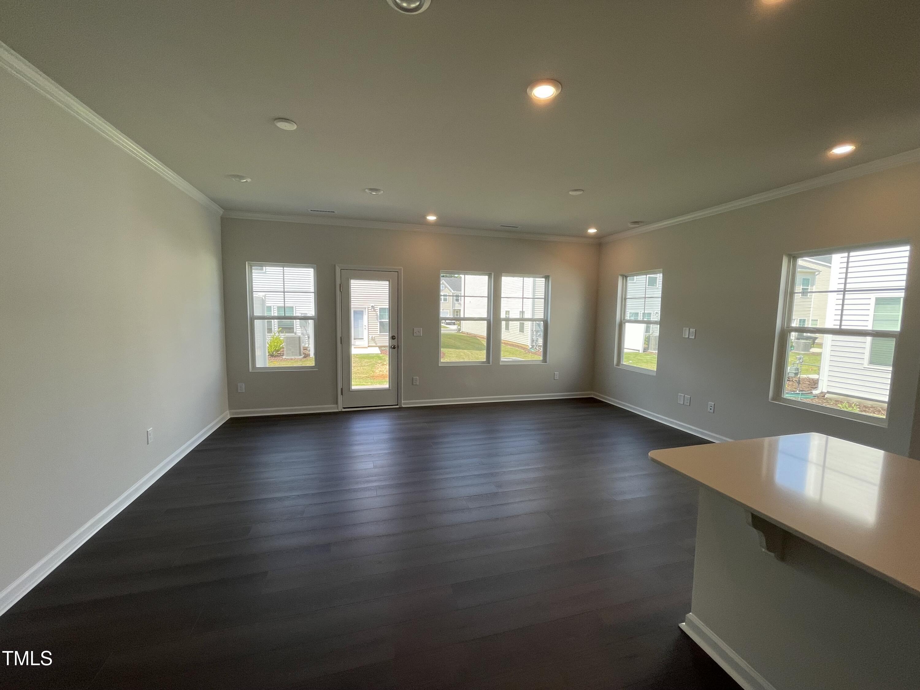 239 Paramount Drive Smithfield, NC 27577 - Photo 5 of 16 an empty room with wooden floor and windows
