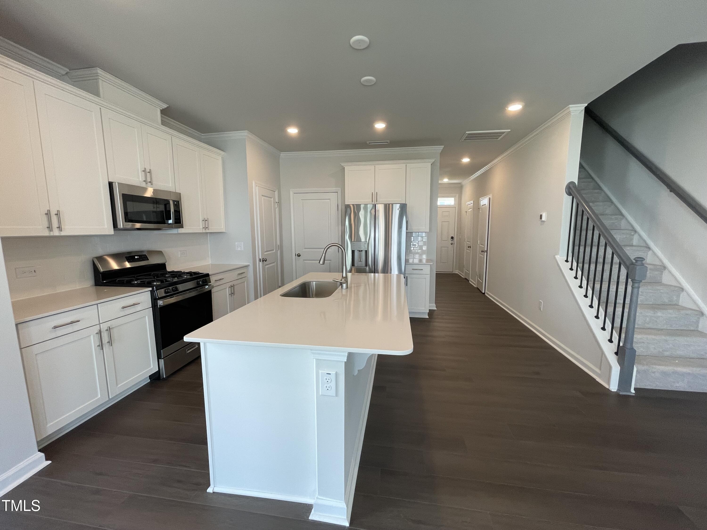 239 Paramount Drive Smithfield, NC 27577 - Photo 8 of 16 a large kitchen with stainless steel appliances kitchen island a stove a sink a refrigerator and a microwave