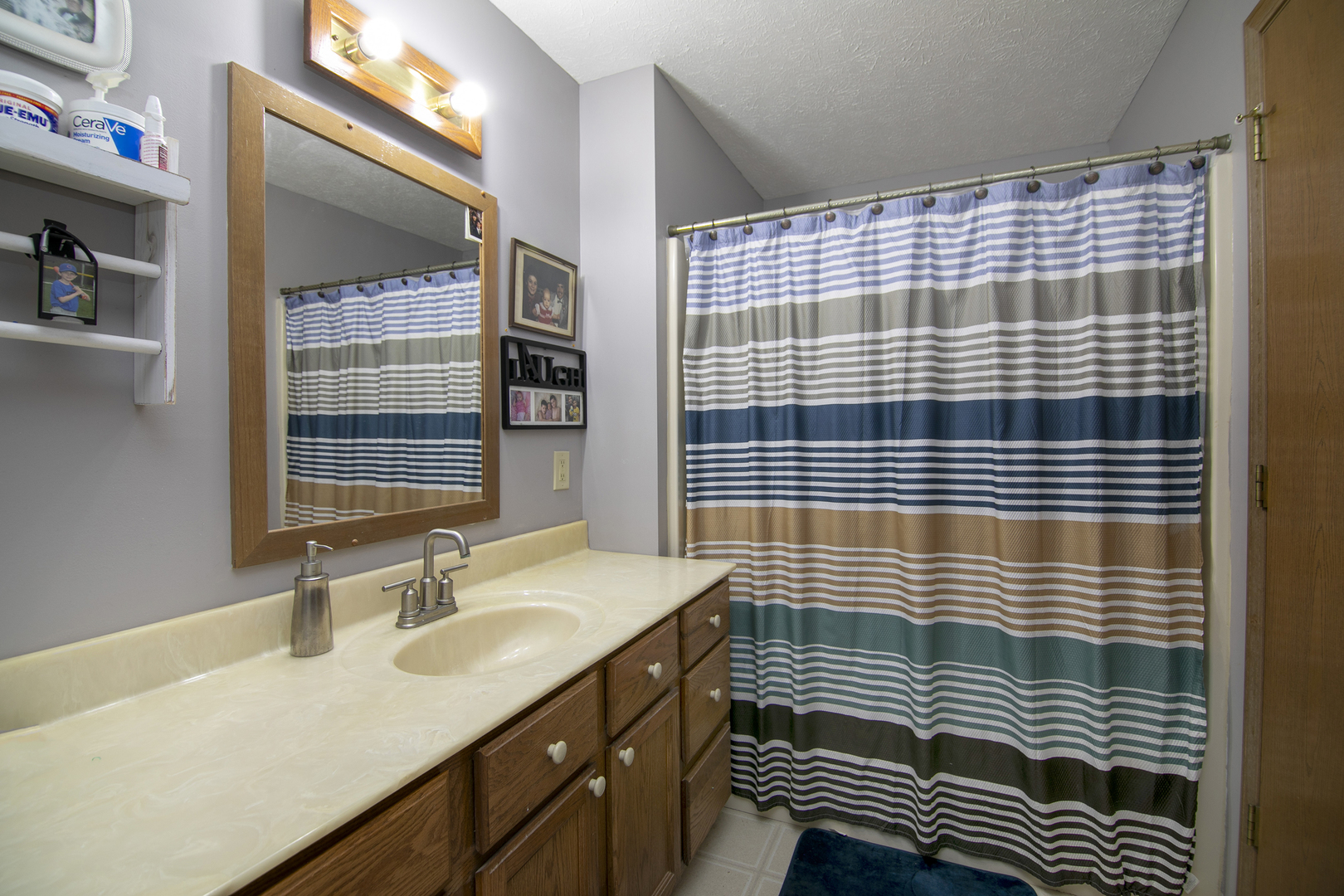 126 East Cleveland Street Cullom, IL 60929 - Photo 13 of 29 a bathroom with a sink a mirror and shower