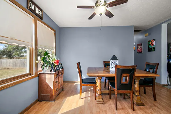 a dining room with furniture potted plants and wooden floor