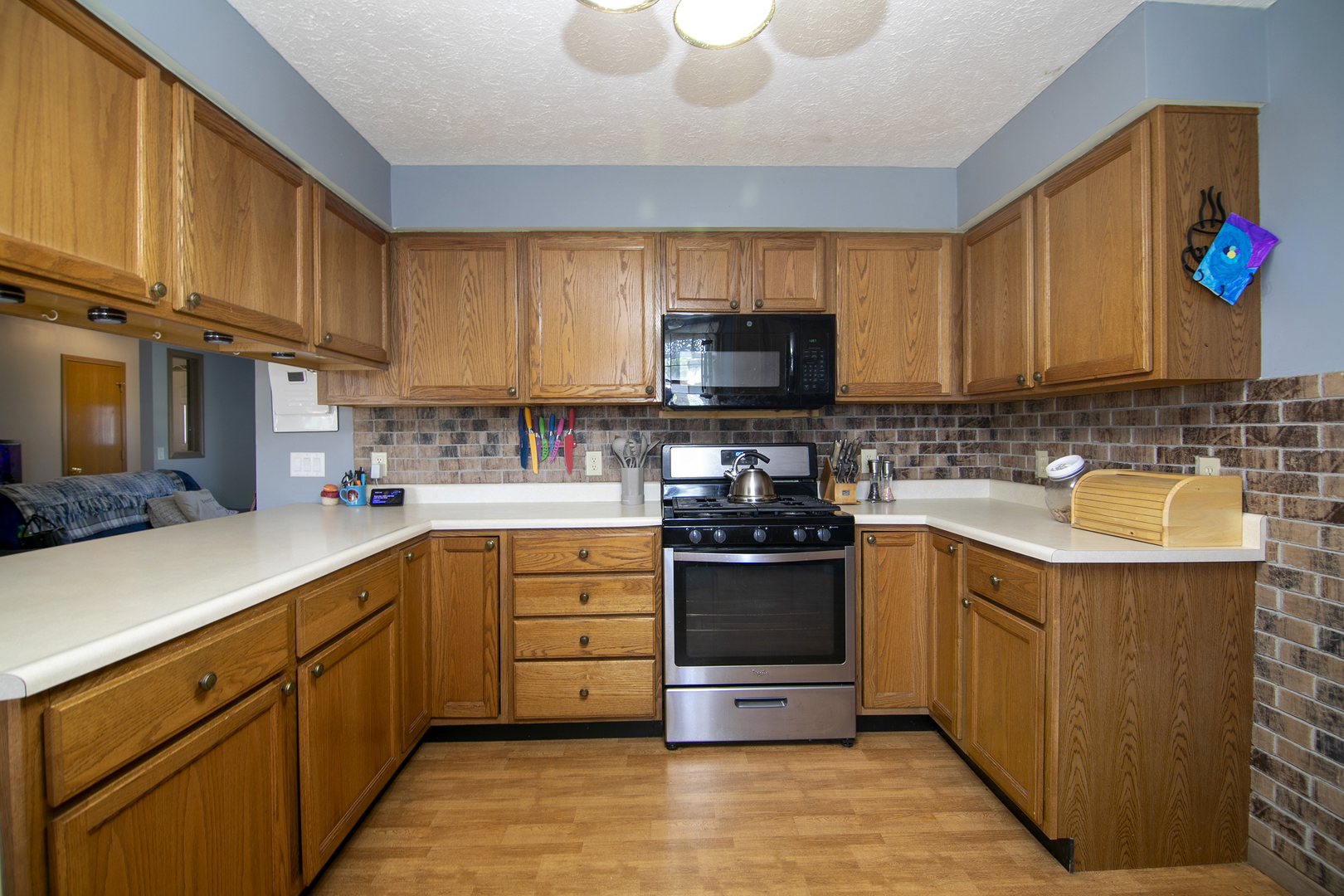 126 East Cleveland Street Cullom, IL 60929 - Photo 7 of 29 a kitchen with stainless steel appliances granite countertop a stove top oven a sink dishwasher and a refrigerator with wooden cabinets