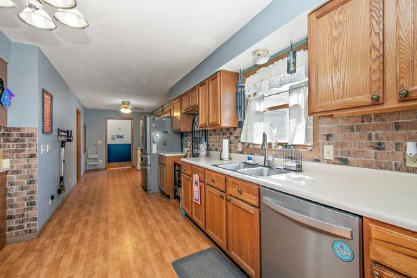 a large kitchen with stainless steel appliances granite countertop a lot of counter space and wooden floors
