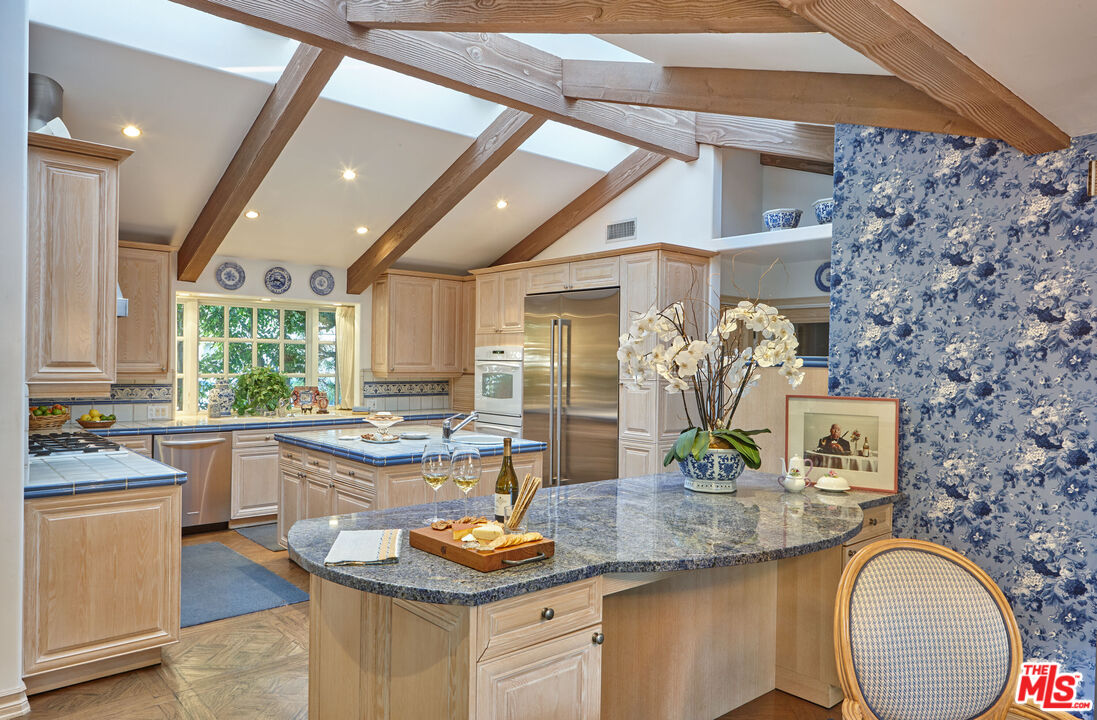 10957 Bellagio Road Los Angeles, CA 90077 - Photo 11 of 18 a kitchen with stainless steel appliances granite countertop a sink stove and cabinets