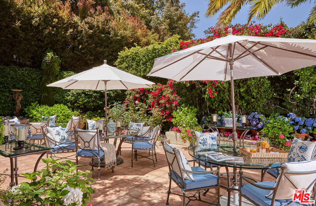 10957 Bellagio Road Los Angeles, CA 90077 - Photo 17 of 18 a view of patio with chairs and table under an umbrella