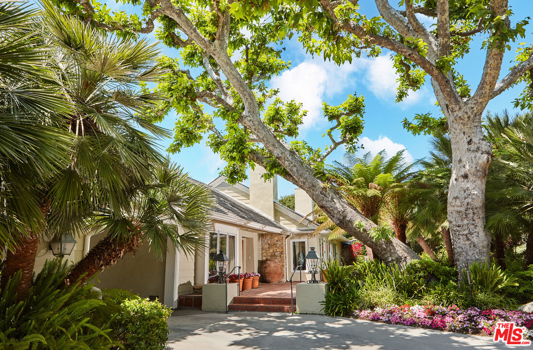 10957 Bellagio Road Los Angeles, CA 90077 - Photo 3 of 18 a view of a white house with a tree in front of it