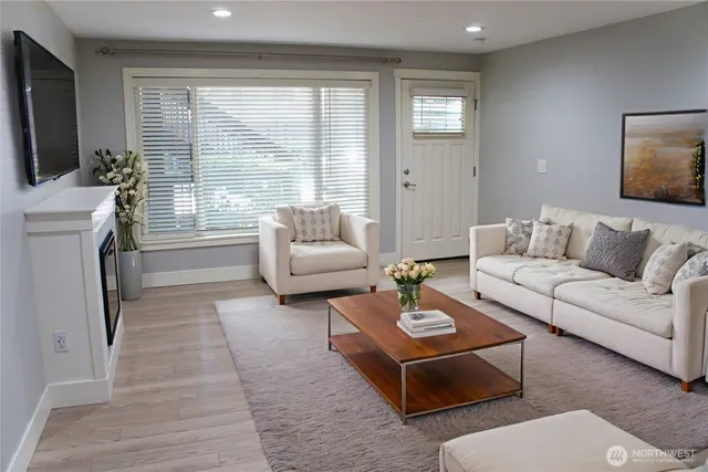 a living room with furniture a large window and a flat screen tv