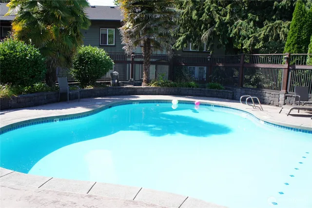 a swimming pool with outdoor seating and yard
