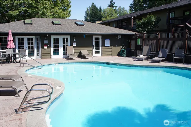a view of a patio with table and chairs potted plants and large tree