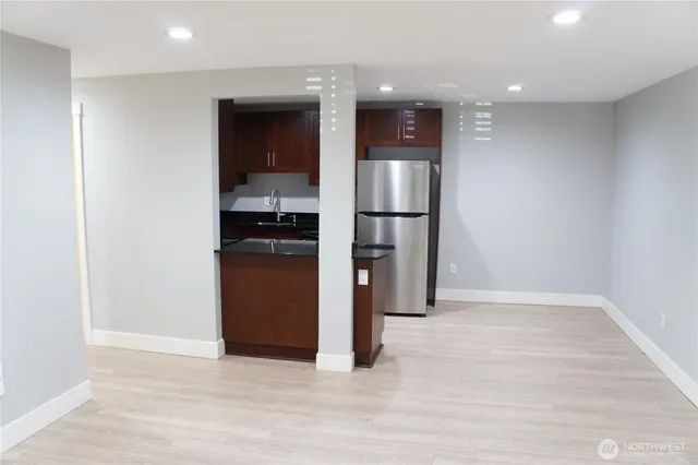a view of kitchen with a refrigerator and a stove top oven
