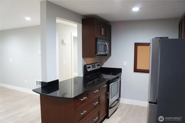 a kitchen with stainless steel appliances granite countertop a sink and a refrigerator