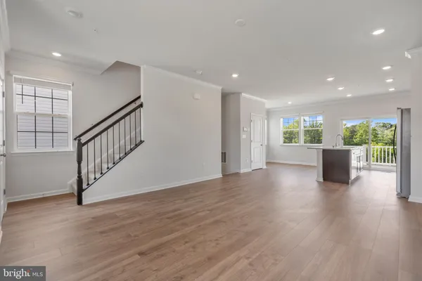 a view of a livingroom with wooden floor stairs and a living room