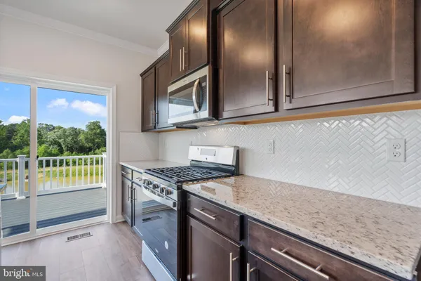 a kitchen with granite countertop cabinets stainless steel appliances and a counter space