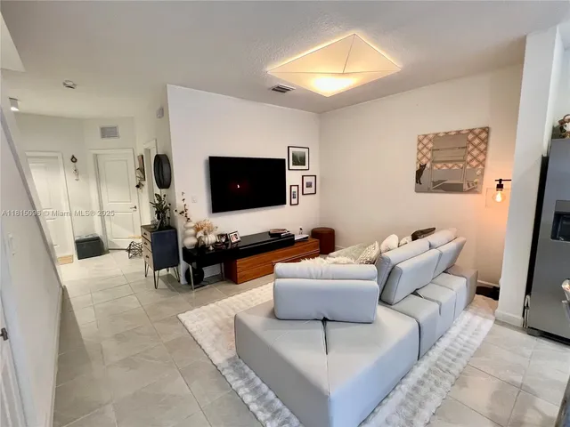 a kitchen with stainless steel appliances granite countertop a stove a refrigerator a kitchen island a table and chairs