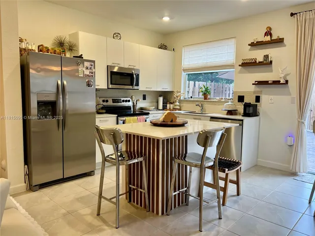 a kitchen with stainless steel appliances granite countertop a refrigerator a stove and a sink