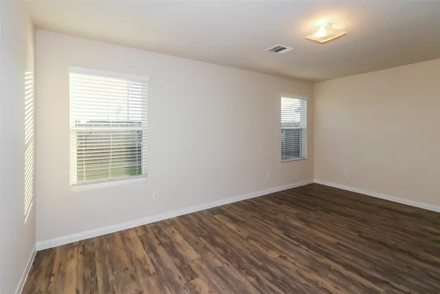 a view of an empty room with wooden floor