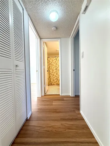 a view of a room with wooden floor and a window