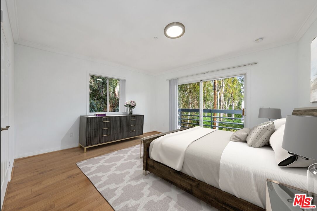 11606 Chenault Street, Unit 403 Los Angeles, CA 90049 - Photo 18 of 21 a bedroom with a bed and a window