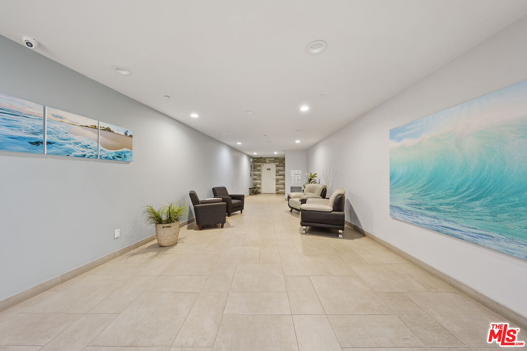 11606 Chenault Street, Unit 403 Los Angeles, CA 90049 - Photo 20 of 21 a living room with furniture and a chandelier