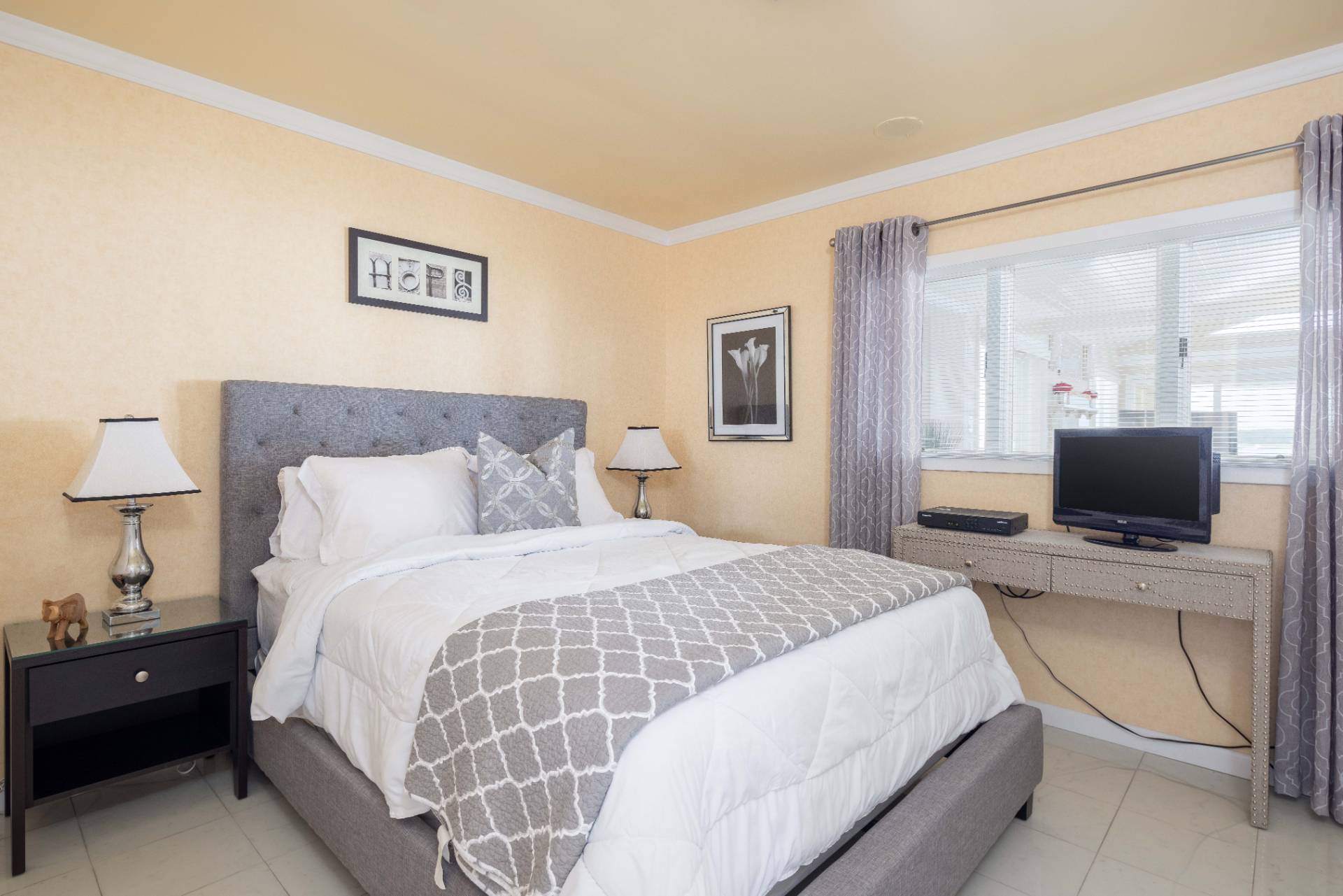 69 B Little Pine Lane East Quogue, NY 11942 - Photo 14 of 34 a bedroom with a bed and a tv