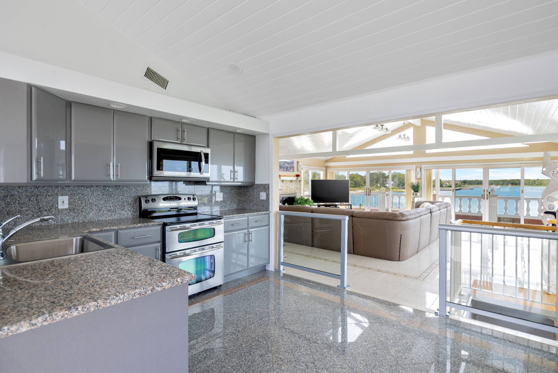 69 B Little Pine Lane East Quogue, NY 11942 - Photo 5 of 34 a kitchen with stainless steel appliances granite countertop a sink stove and microwave