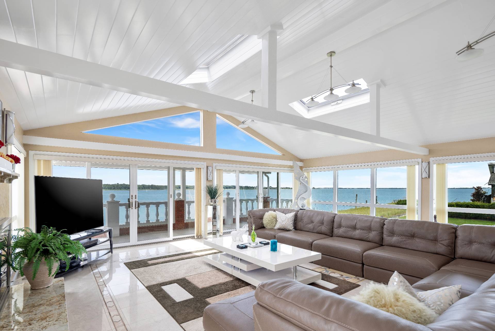 69 B Little Pine Lane East Quogue, NY 11942 - Photo 7 of 34 a living room with furniture a flat screen tv and a floor to ceiling window