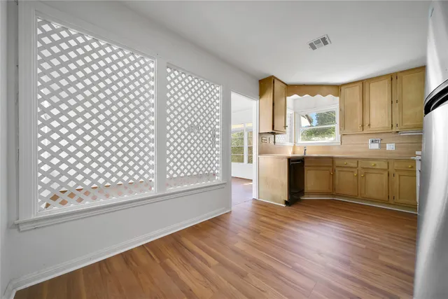 a view of a kitchen with wooden floor and a window