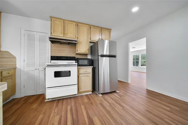 a kitchen with wooden floors and white appliances