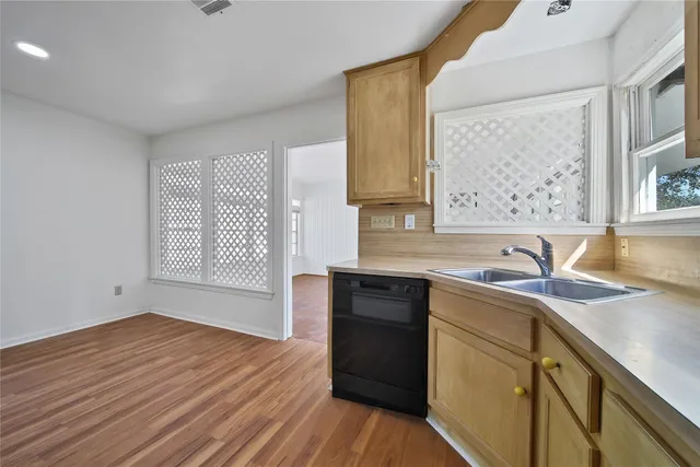 a kitchen with stainless steel appliances granite countertop a sink dishwasher a stove with wooden cabinets and floors