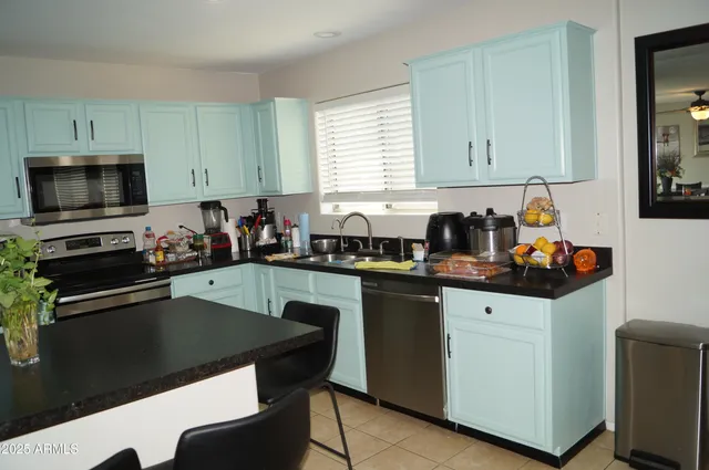 a kitchen with stainless steel appliances a sink and a refrigerator