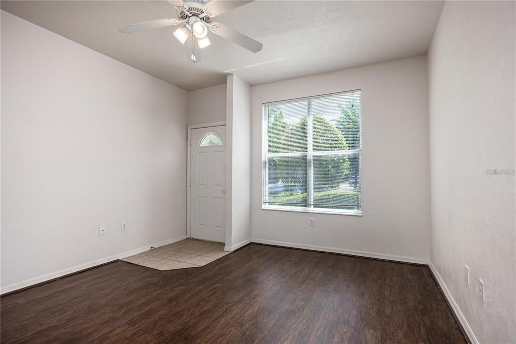 3510 Southwest 30th Way, Unit 158 Gainesville, FL 32608 - Photo 6 of 27 an empty room with wooden floor chandelier fan and windows