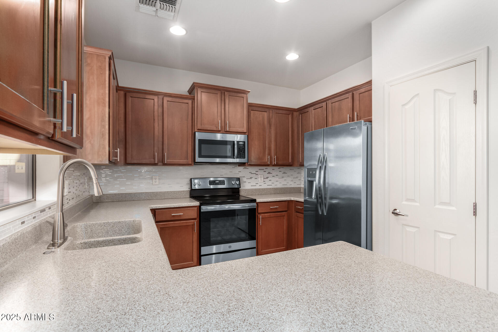 15820 North 74th Drive Peoria, AZ 85382 - Photo 11 of 33 a kitchen with stainless steel appliances granite countertop a refrigerator stove microwave and sink