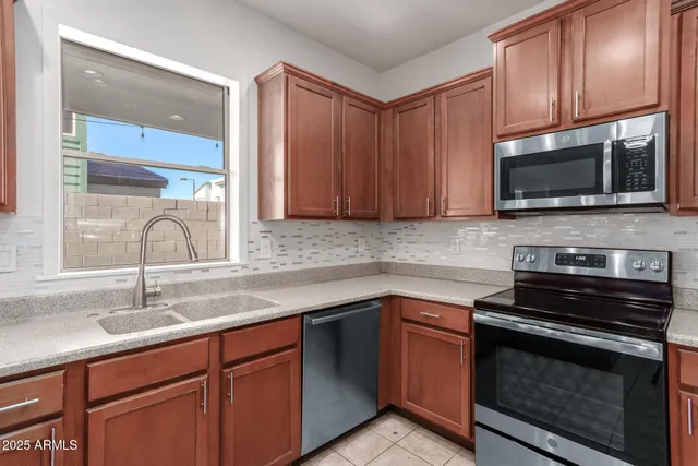 a kitchen with granite countertop cabinets stainless steel appliances and a sink