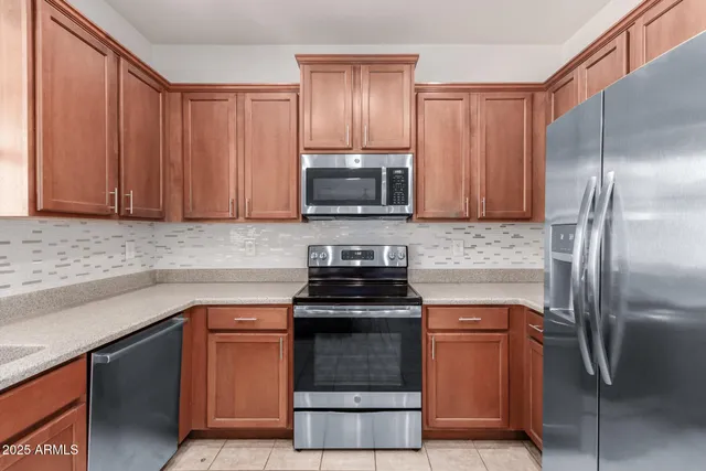 a kitchen with granite countertop a stove and a refrigerator
