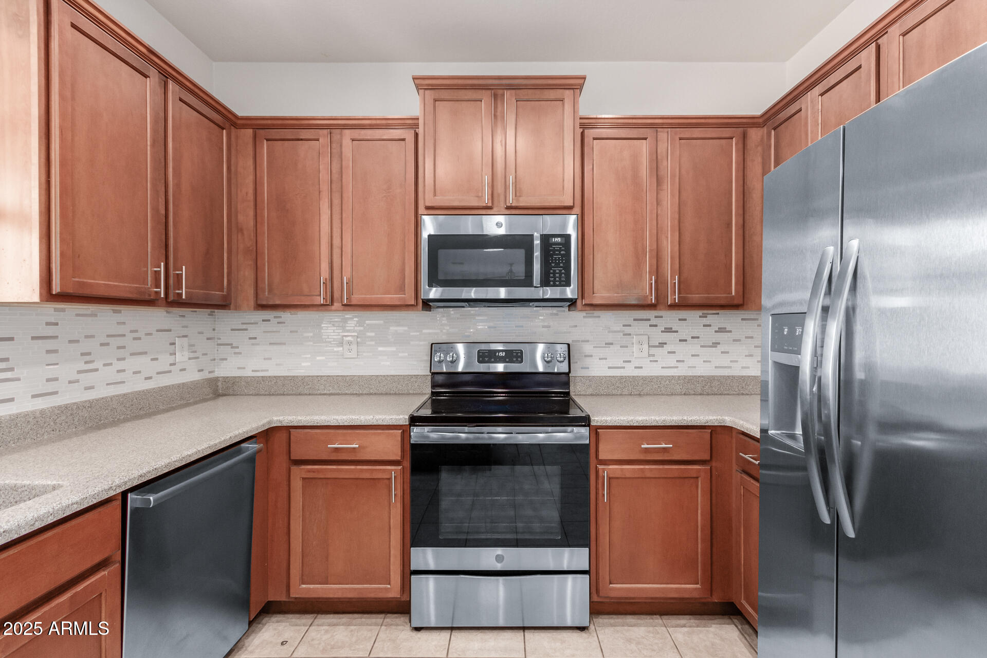 15820 North 74th Drive Peoria, AZ 85382 - Photo 15 of 33 a kitchen with granite countertop a stove and a refrigerator